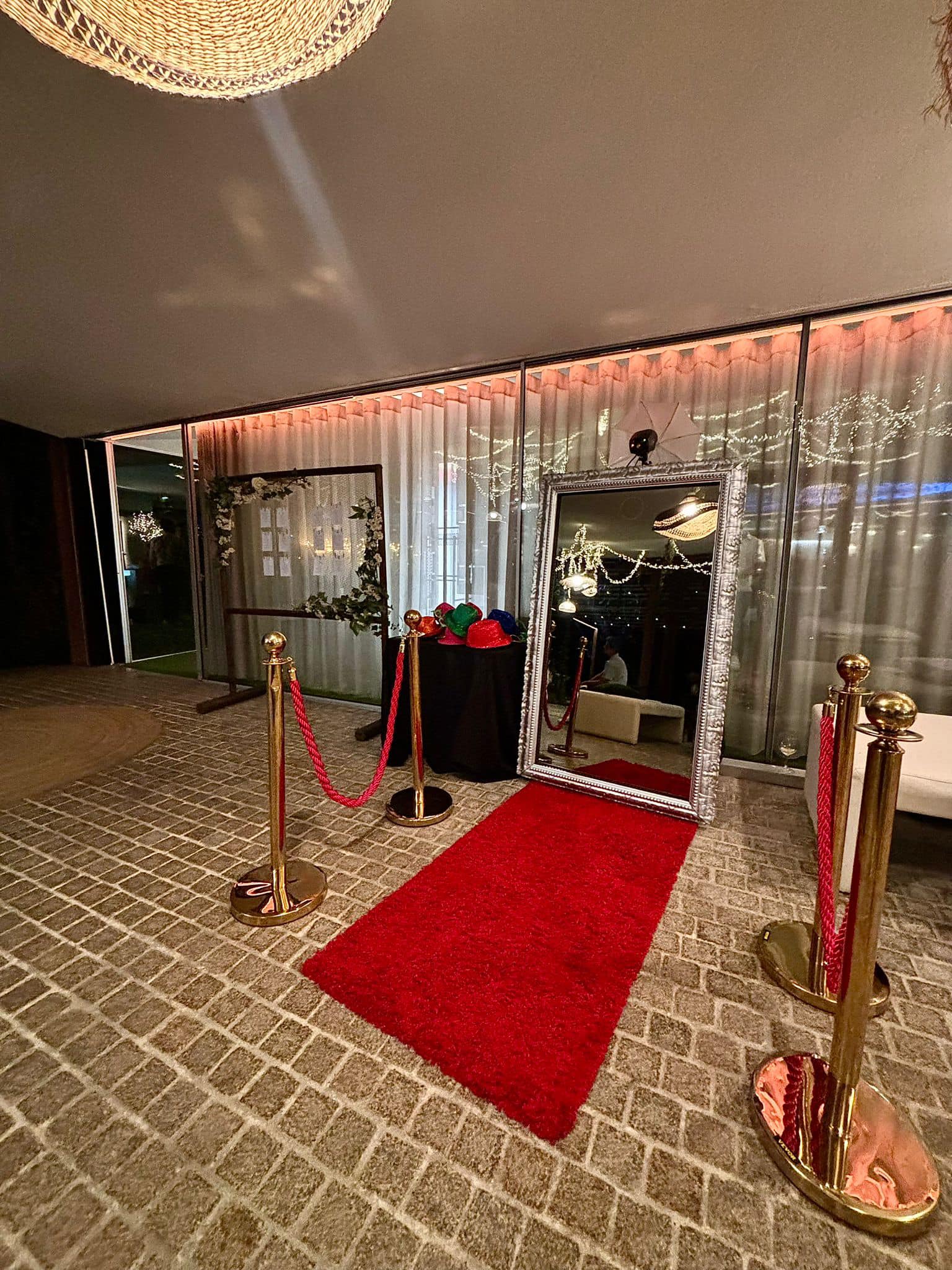 Espelho mágico com moldura prateada e tapete vermelho